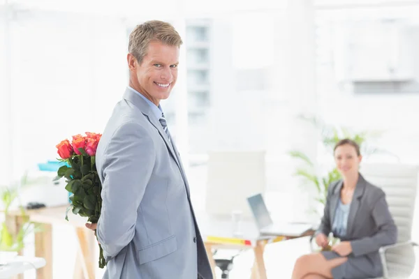 Geschäftsmann hält Blumen zurück — Stockfoto