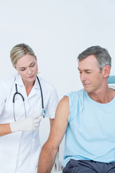 Doctor doing an injection to her patient — Stock Photo, Image