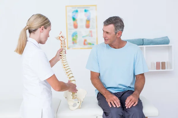 Doktor hastasını gösteren anatomik omurga — Stok fotoğraf