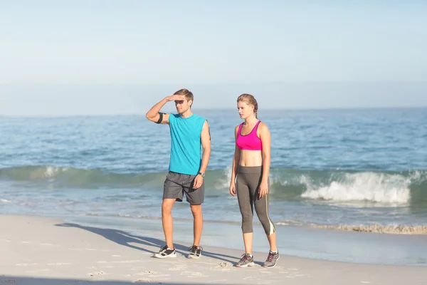 Sporting couple looking far away — Stock Photo, Image