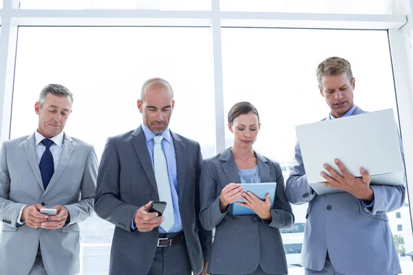 Colleghi di lavoro che utilizzano dispositivi multimediali — Foto Stock