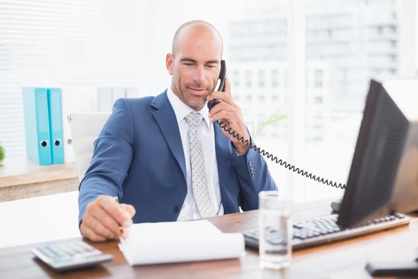 Businessman on the phone and writing notes — Stockfoto