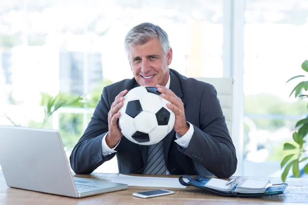 Empresário sorridente segurando bola de futebol — Fotografia de Stock