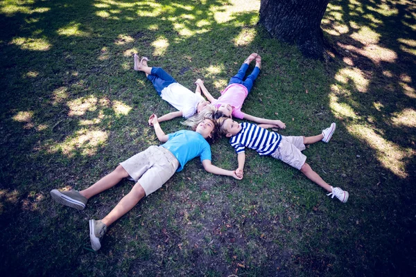 Feliz familia acostada en el parque — Foto de Stock