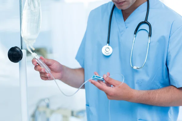 Médico examinando goteo intravenoso — Foto de Stock