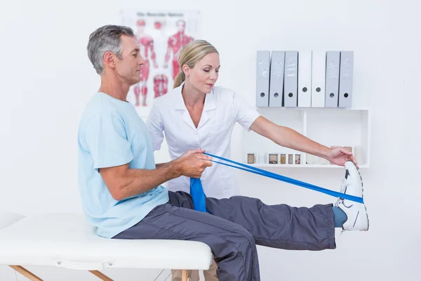 Médico examinando suas pernas traseiras paciente — Fotografia de Stock