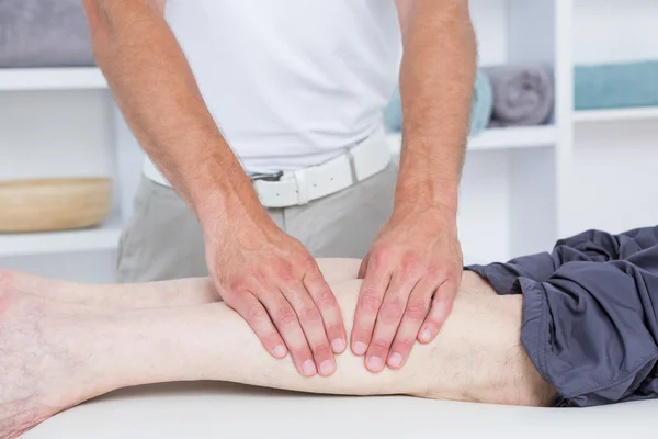 Physiotherapeut macht Beinmassage für seinen Patienten — Stockfoto