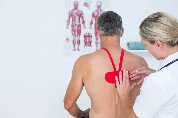 Médico examinando a su paciente — Foto de Stock