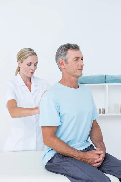 Doutor examinando seu paciente de volta — Fotografia de Stock