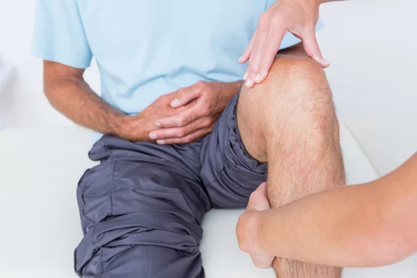 Médico examinando su rodilla paciente — Foto de Stock