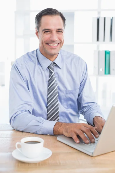 Χαμογελώντας επιχειρηματίας χρησιμοποιώντας τον υπολογιστή του — Φωτογραφία Αρχείου