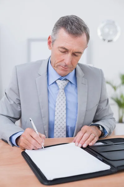 Uomo d'affari che scrive su un giornale — Foto Stock