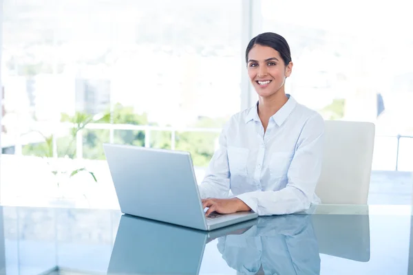 Empresária sorridente trabalhando com seu laptop — Fotografia de Stock