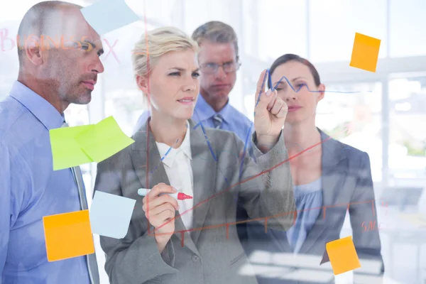 Geschäftsfrau zeichnet Grafik auf die Tafel — Stockfoto