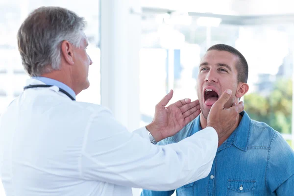 Doctor examinando a sus pacientes ganglio —  Fotos de Stock
