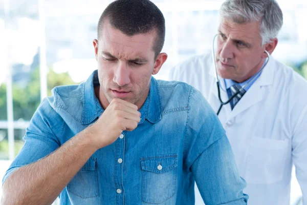 Doctor auscultando a sus pacientes de vuelta — Foto de Stock