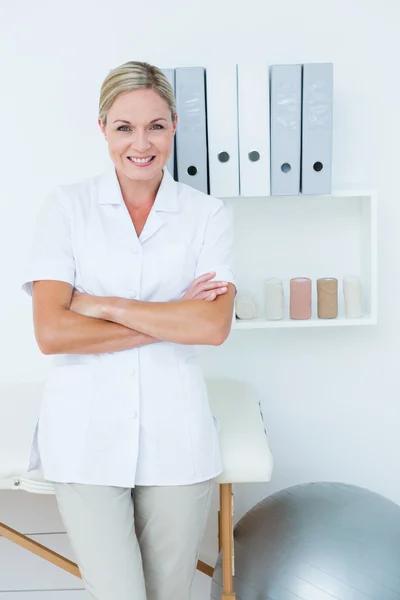 Heureux médecin regardant la caméra avec les bras croisés — Photo