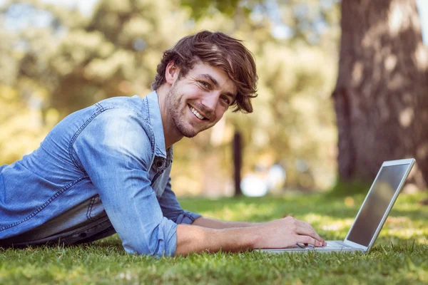 Bonito hipster usando laptop no parque — Fotografia de Stock