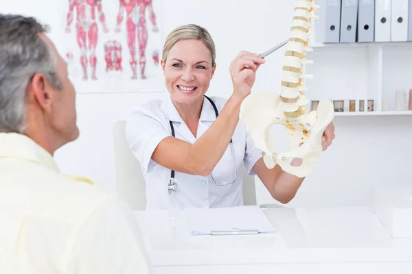 Médico mostrando a su paciente un modelo de columna vertebral —  Fotos de Stock