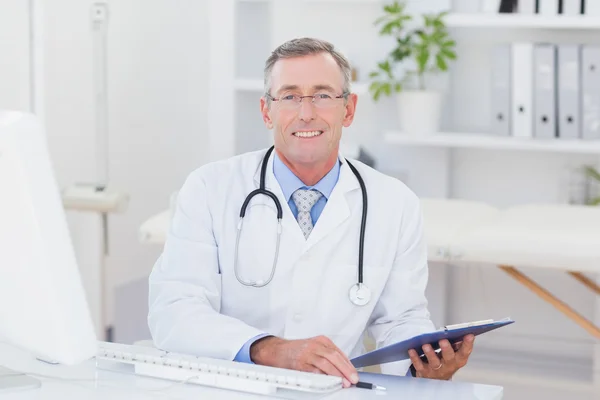 Médecin regardant la caméra avec presse-papiers — Photo