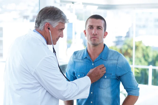 Doctor auscultando a sus pacientes en el pecho —  Fotos de Stock