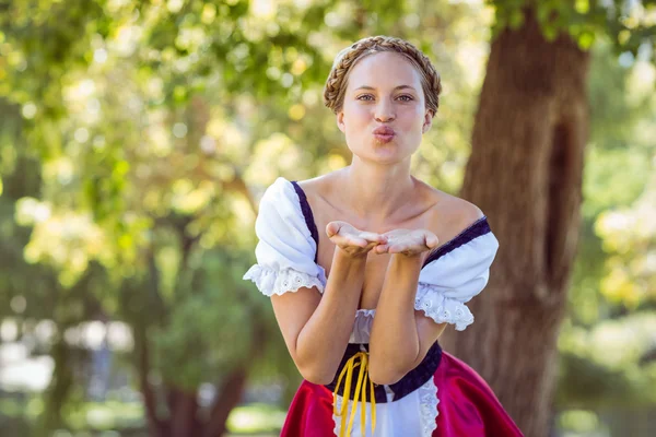 Vackra oktoberfest blonda blåser en kyss i parken — Stockfoto