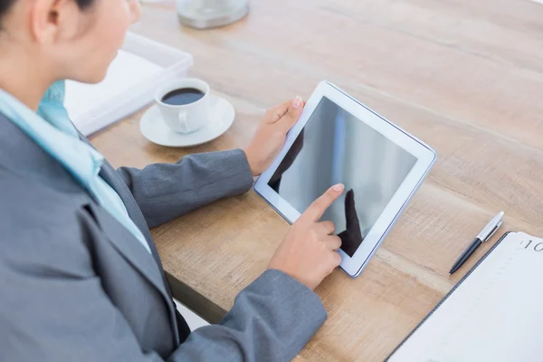 Concentrating businesswoman using a tablet — Stok fotoğraf