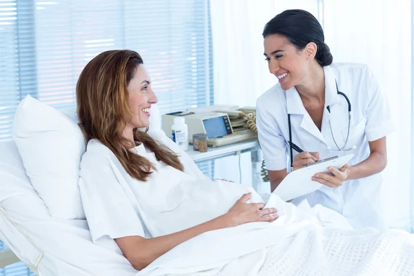 Sorridente donna incinta con il suo medico — Foto Stock