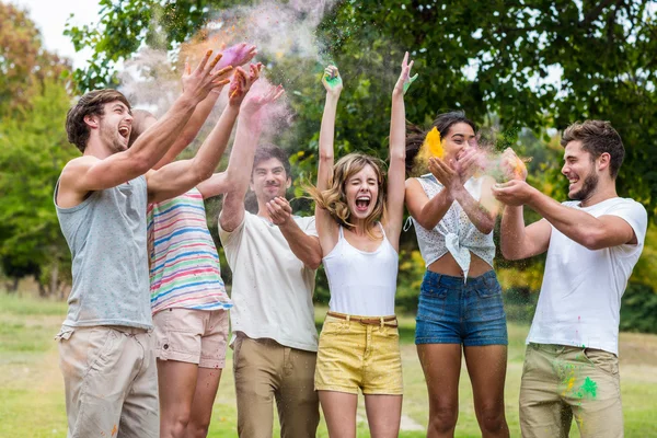 Glückliche Freunde, die mit Pulverfarbe werfen — Stockfoto