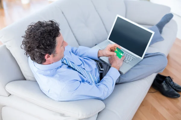 Hombre de negocios haciendo compras en línea en el sofá —  Fotos de Stock