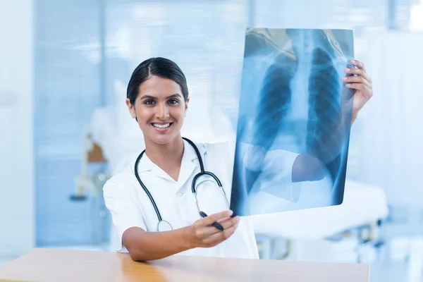 Улыбающийся доктор анализирует рентген — стоковое фото