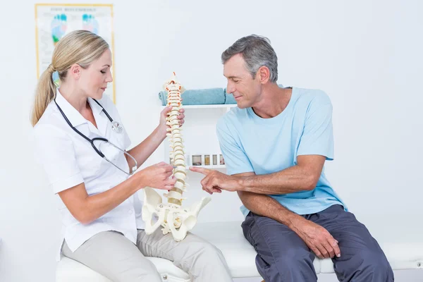 Médico mostrando columna anatómica a su paciente — Foto de Stock