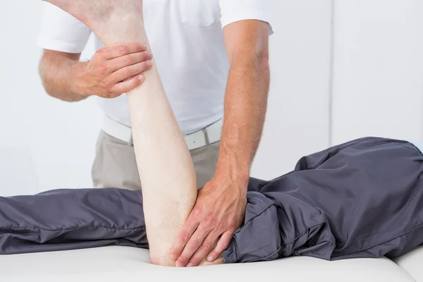 Physiotherapist doing leg massage to his patient — Stock Photo, Image