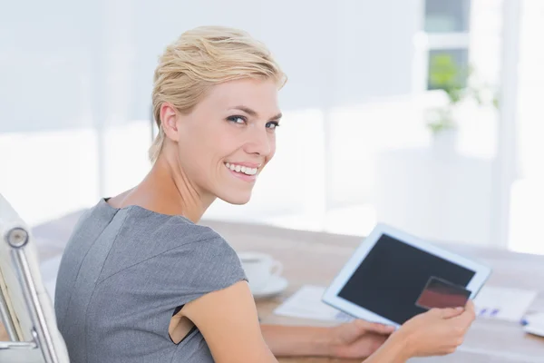 Smiling businesswoman holding credit card and tablet — 스톡 사진