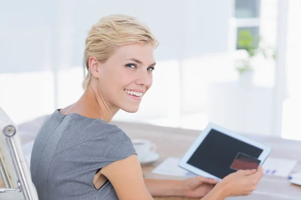 Empresária sorridente segurando cartão de crédito e tablet — Fotografia de Stock