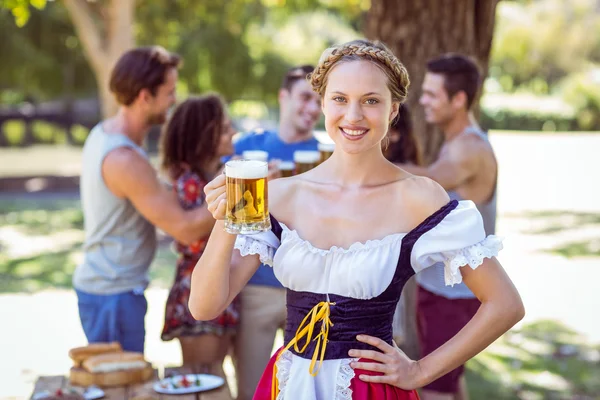 Schöne Oktoberfest-Blondine prostet im Park zu — Stockfoto