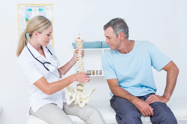 Médico mostrando columna anatómica a su paciente — Foto de Stock