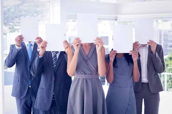 Business colleagues hiding their face with paper — Stock Photo, Image