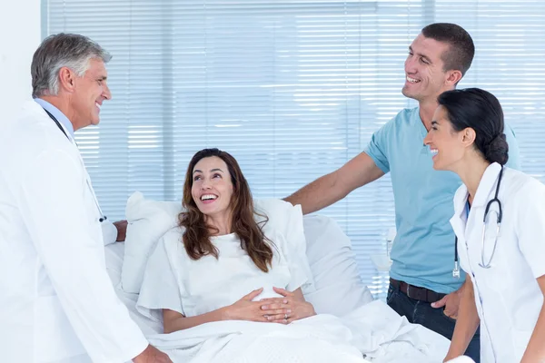 Budoucí rodiče mluví s úsměvem a lékaři — Stock fotografie