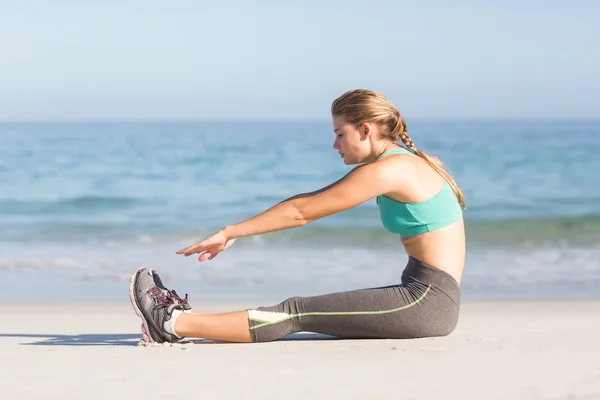 Fit woman stretching beside the sea — Zdjęcie stockowe