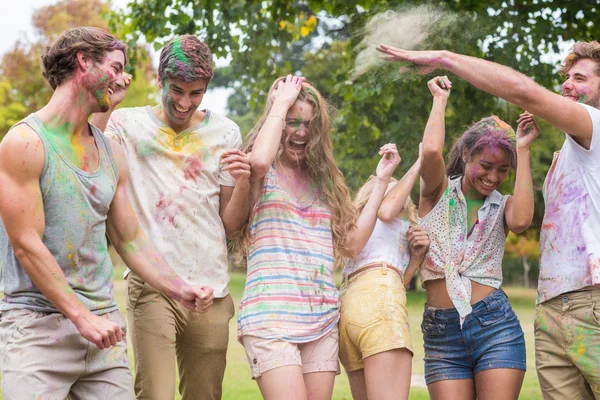 Glückliche Freunde, die mit Pulverfarbe werfen — Stockfoto
