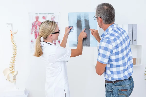 Доктор показывает рентген пациентке — стоковое фото