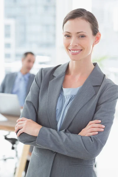 Mujer de negocios sonriente con colegas detrás —  Fotos de Stock