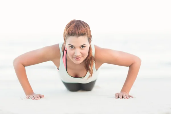 Beautiful brunette doing push ups — ストック写真