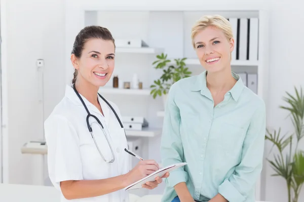 Arzt und Patient lächeln in die Kamera — Stockfoto