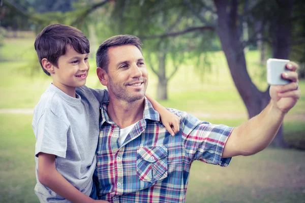 Apa és fia, a park vesz egy selfie — Stock Fotó