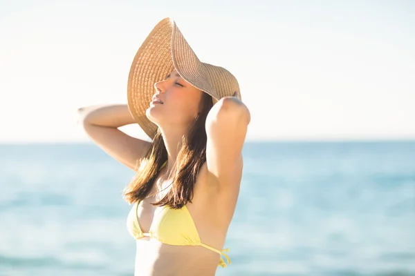 Brunette relaxing with a straw hat — Stockfoto