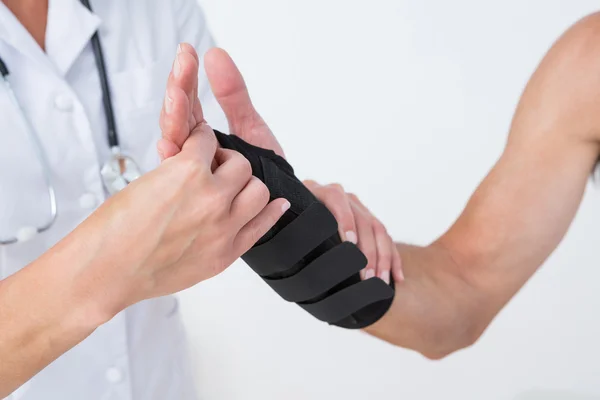 Doctor examining a man wrist — Stock Photo, Image