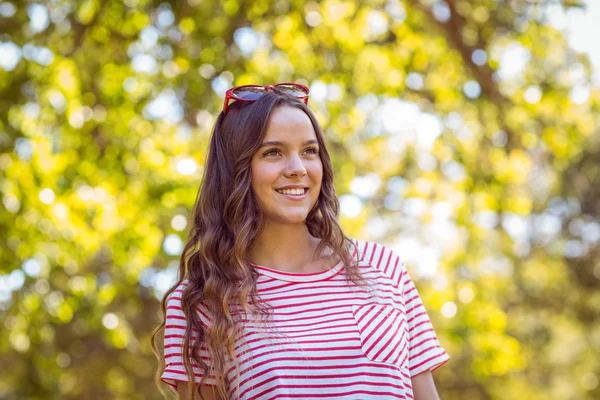 Půvabná brunetka s úsměvem v parku — Stock fotografie