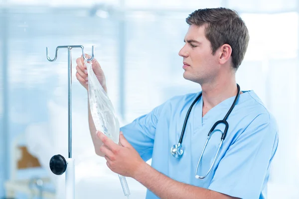 Médico examinando gotejamento intravenoso — Fotografia de Stock